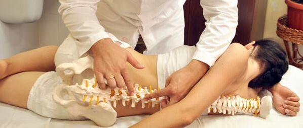 The doctor shows osteochondrosis of the spine